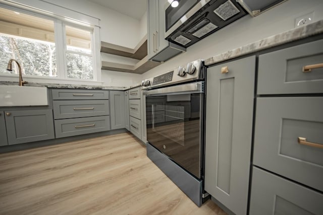 1056 Old Newport Hwy, Dandridge, TN 37725 - kitchen featuring gray cabinetry, stainless steel electric range oven, light wood-type flooring, and light stone countertops