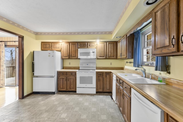 kitchen featuring white appliances, ornamental molding, and sink