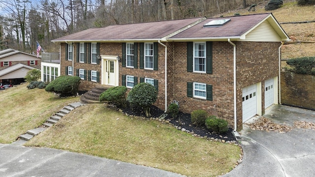 bi-level home with a front yard and a garage