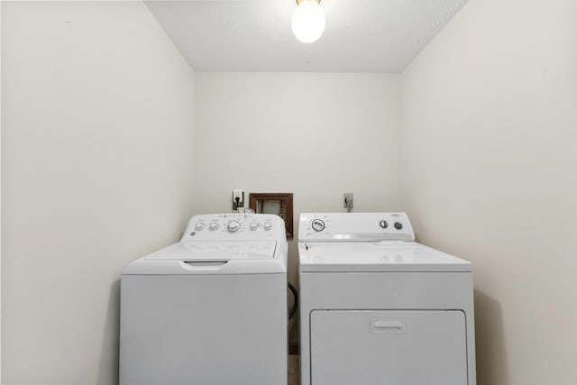 laundry area featuring washing machine and clothes dryer and a textured ceiling