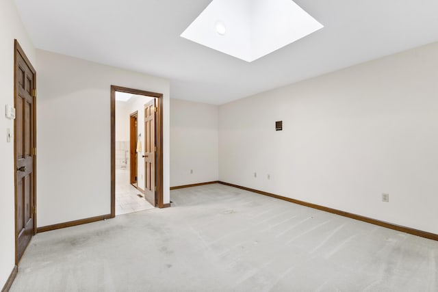 carpeted empty room with a skylight