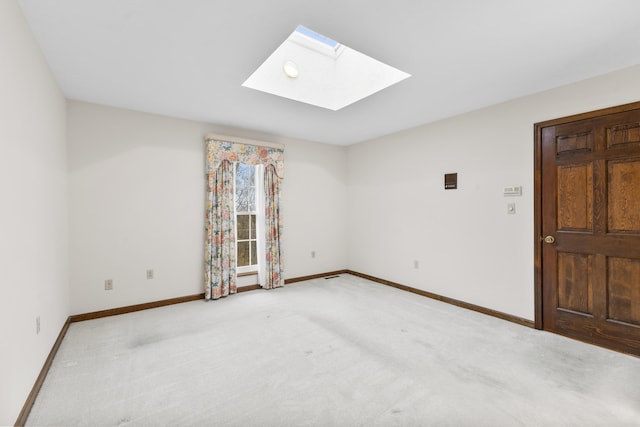 carpeted empty room featuring a skylight