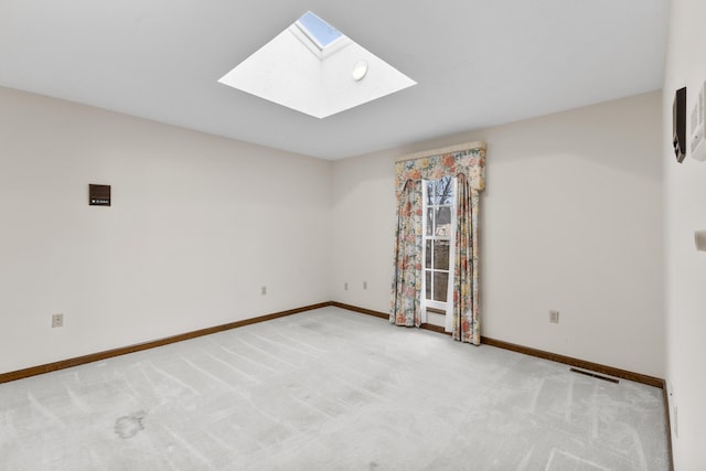 empty room with a skylight and light colored carpet