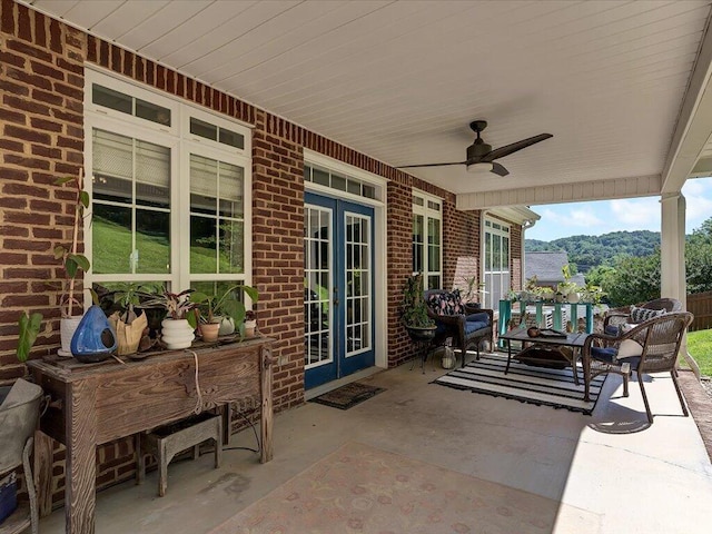 view of patio / terrace featuring a mountain view, french doors, and ceiling fan