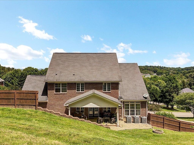 back of property featuring a lawn, cooling unit, and a patio