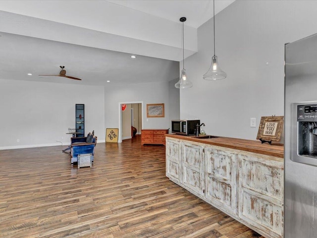 kitchen with ceiling fan, sink, wood-type flooring, pendant lighting, and stainless steel fridge with ice dispenser