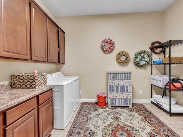 laundry room featuring cabinets, light tile patterned floors, and washer and dryer