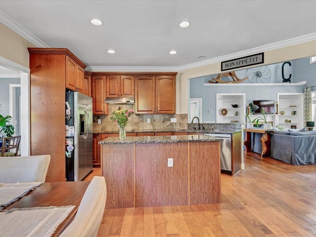 kitchen featuring appliances with stainless steel finishes, a kitchen island, and dark stone counters