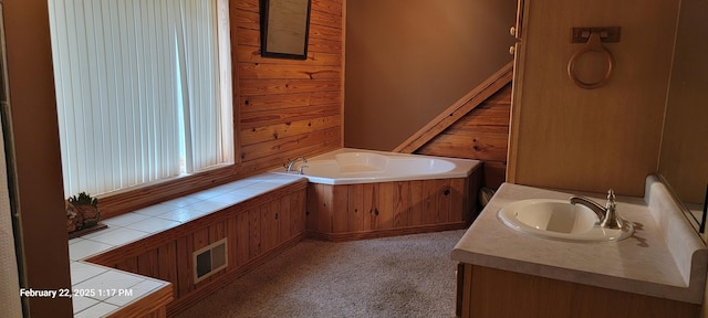 full bathroom with carpet, visible vents, wooden walls, vanity, and a bath