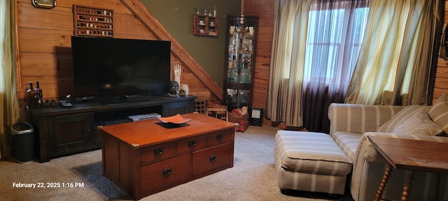 living area featuring light carpet and wooden walls