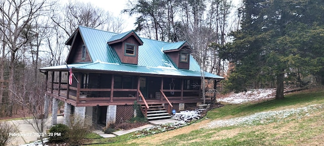 view of front of property with a sunroom, metal roof, and stairs