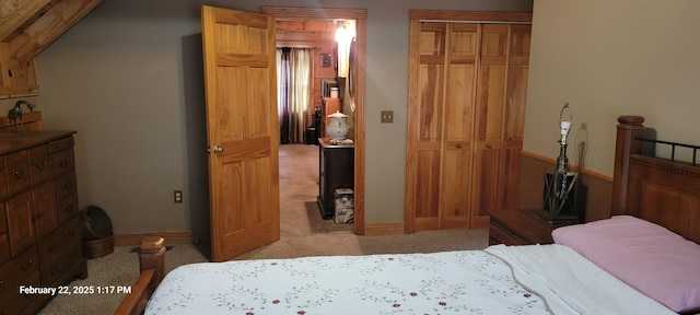 bedroom with baseboards, a closet, and light colored carpet