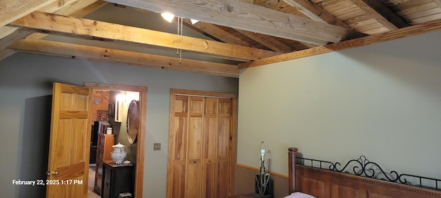 bedroom featuring a closet, wooden ceiling, and lofted ceiling with beams