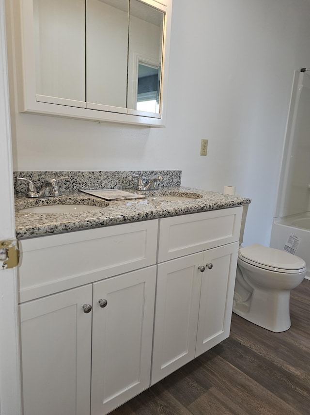 full bathroom featuring hardwood / wood-style flooring, vanity, toilet, and bathing tub / shower combination