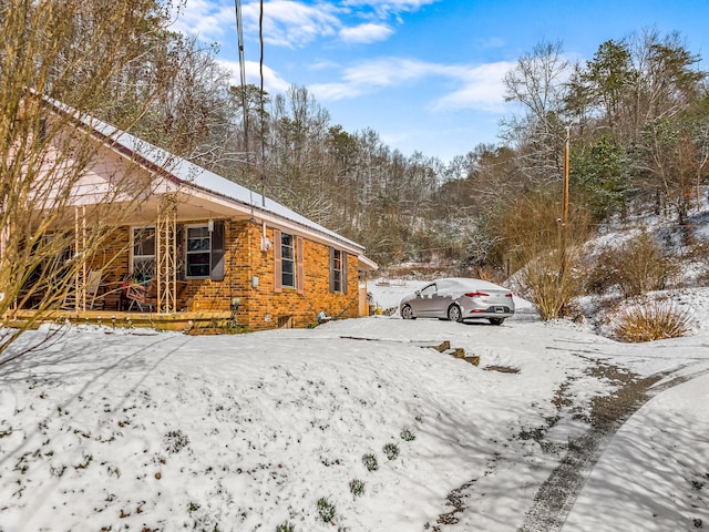 245 Fox Branch Rd, Kyles Ford, TN 37765 - view of snowy exterior with brick siding and covered porch