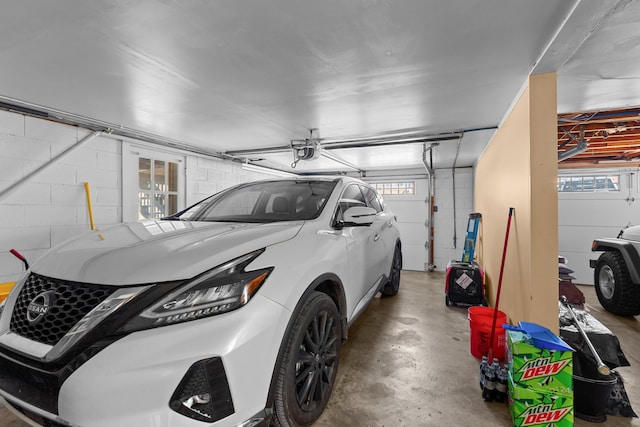 garage featuring a garage door opener and concrete block wall