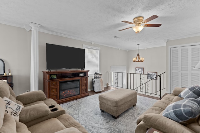 living room with baseboards, ornamental molding, a textured ceiling, and a glass covered fireplace