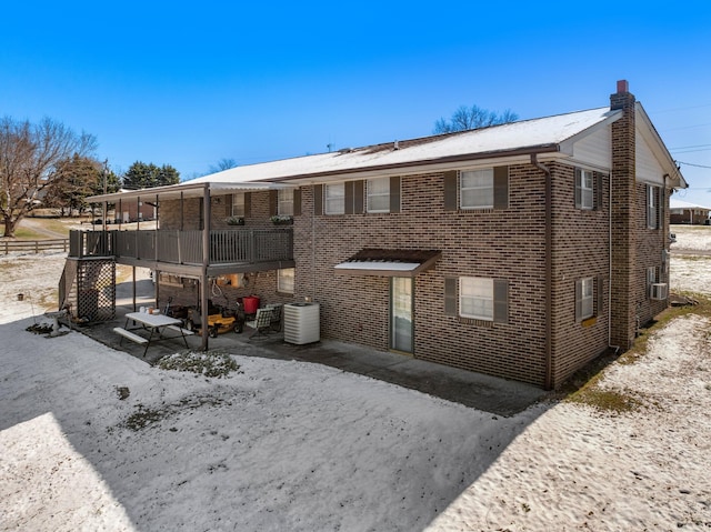 exterior space with brick siding and a chimney