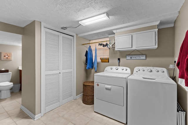 laundry area with laundry area, baseboards, washer and clothes dryer, and a textured ceiling