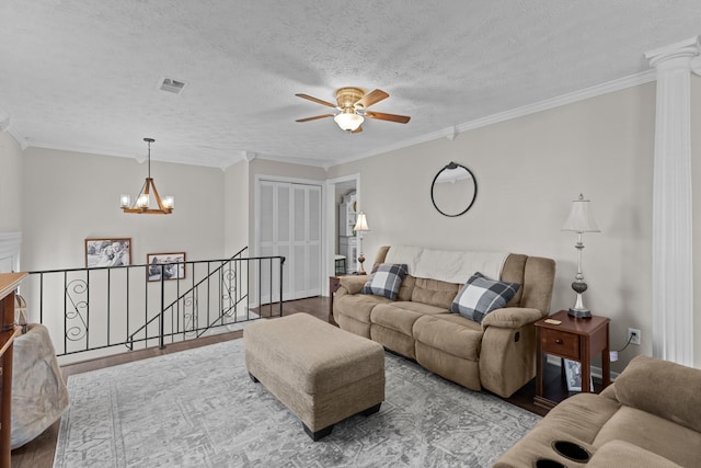 living room featuring light wood finished floors, a textured ceiling, visible vents, and crown molding