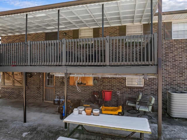 rear view of property featuring brick siding and central AC unit