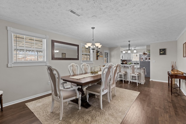 dining room with a chandelier, dark wood-style flooring, visible vents, and baseboards