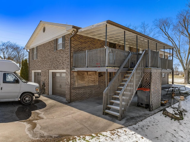 view of home's exterior featuring a porch, concrete driveway, brick siding, and stairs