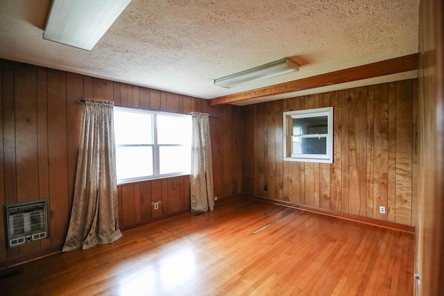 311 Locust St, Morristown, TN 37813 - unfurnished room with heating unit, wood finished floors, a textured ceiling, wooden walls, and baseboards