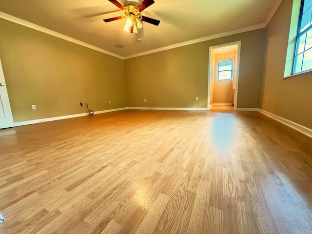 empty room featuring crown molding, baseboards, ceiling fan, and wood finished floors