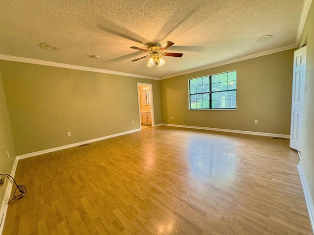 spare room featuring a ceiling fan, a textured ceiling, crown molding, wood finished floors, and baseboards