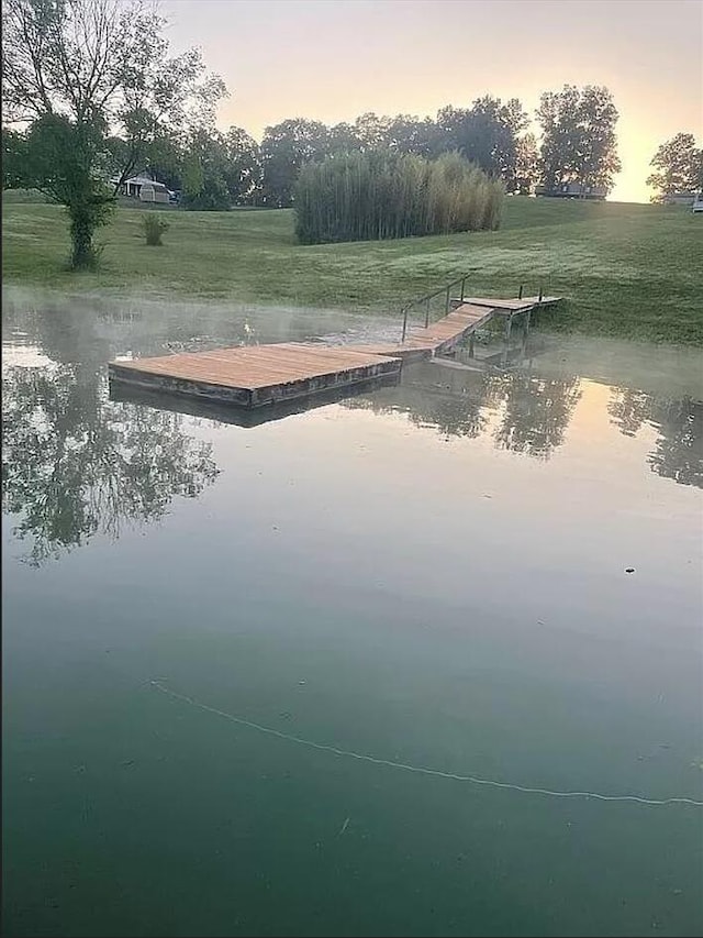 surrounding community featuring a floating dock and a water view