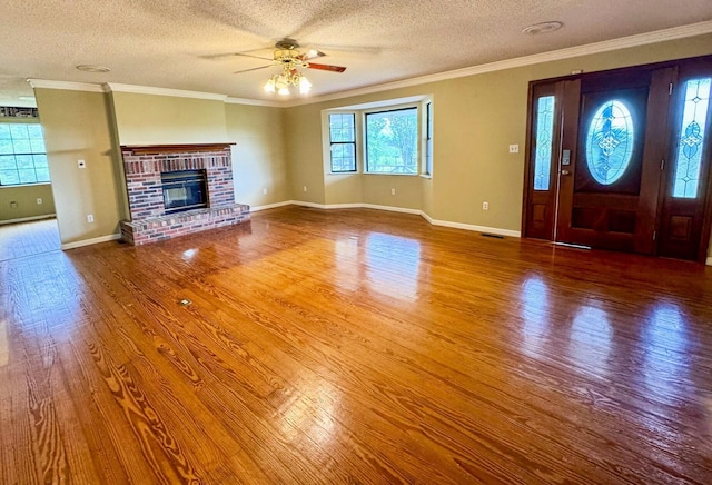 2131 Ted Moore Rd, Dandridge, TN 37725 - unfurnished living room with wood finished floors, a ceiling fan, a textured ceiling, crown molding, and a brick fireplace