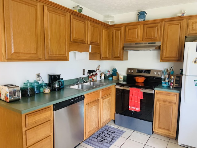 kitchen with light tile patterned flooring, a textured ceiling, stainless steel appliances, and sink