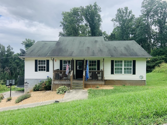 view of front of property featuring a front lawn, covered porch, and a trampoline