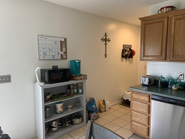 kitchen featuring light tile patterned flooring and stainless steel dishwasher