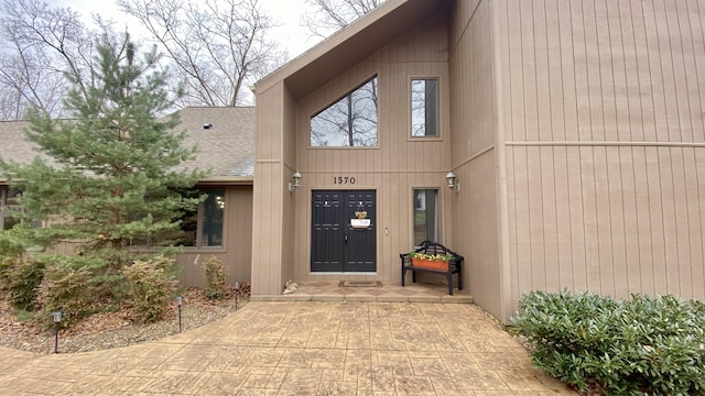 entrance to property with a shingled roof