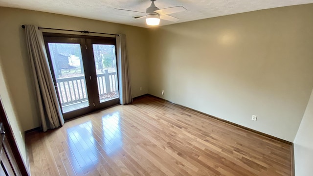 unfurnished room with a textured ceiling, ceiling fan, light wood finished floors, and baseboards