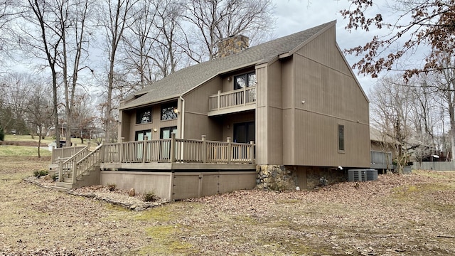 view of home's exterior with a balcony, a chimney, cooling unit, and roof with shingles