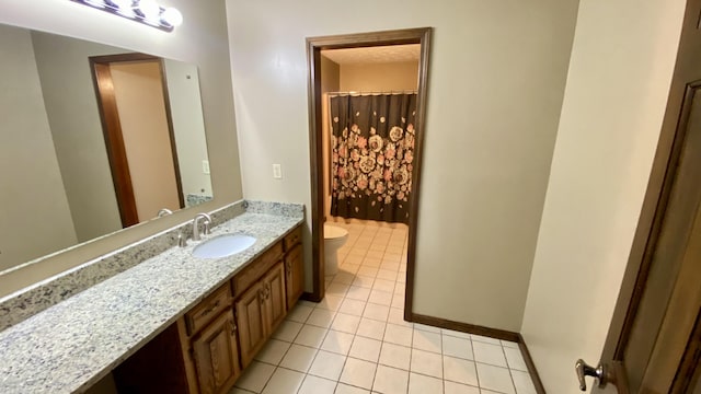 bathroom with toilet, tile patterned flooring, vanity, and baseboards