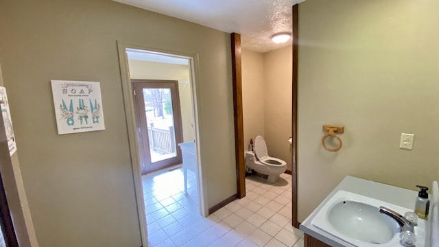 bathroom featuring toilet, a textured ceiling, tile patterned flooring, and vanity