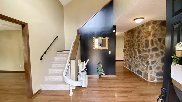 staircase with baseboards and wood finished floors