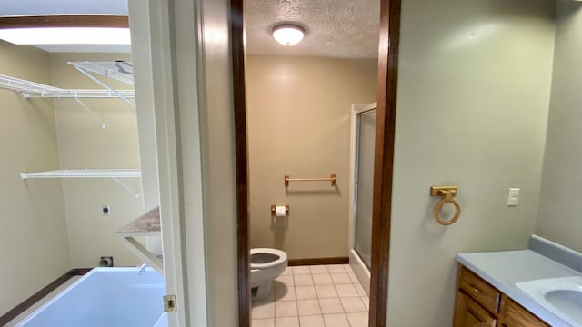 full bath with a stall shower, toilet, tile patterned floors, a textured ceiling, and vanity