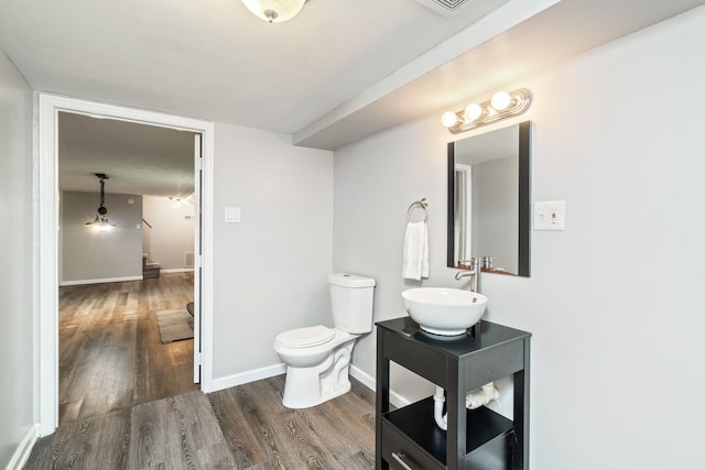 bathroom with hardwood / wood-style floors, vanity, and toilet