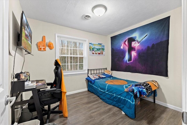 bedroom with hardwood / wood-style floors and a textured ceiling