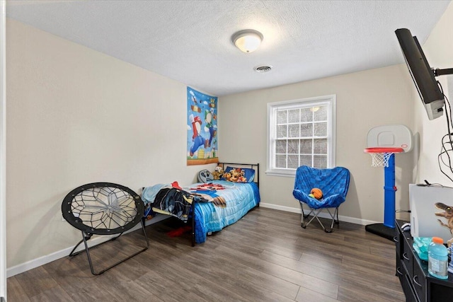 bedroom with dark wood-type flooring and a textured ceiling