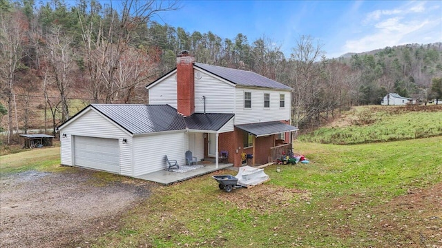 rear view of property with a garage and a yard