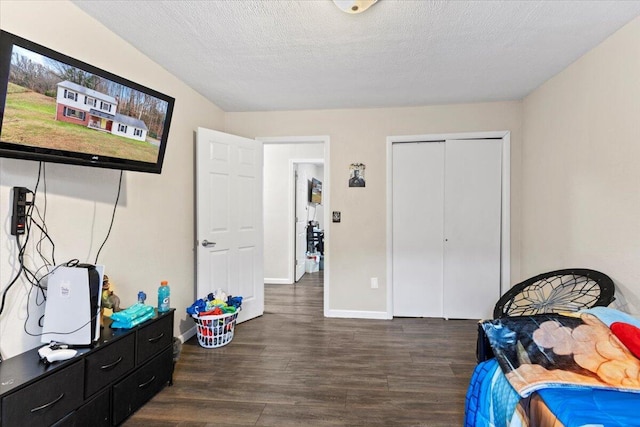 bedroom with dark hardwood / wood-style floors, a textured ceiling, and a closet