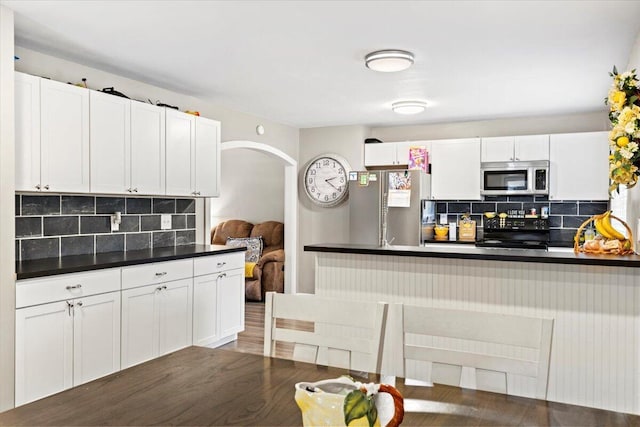 kitchen featuring tasteful backsplash, stainless steel appliances, dark hardwood / wood-style floors, and white cabinets