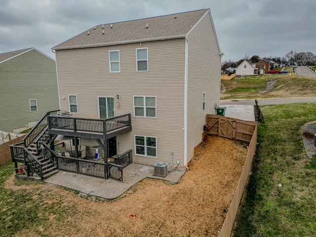 rear view of house with a patio, a deck, cooling unit, and a lawn