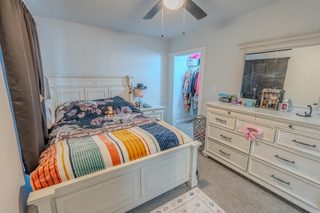 carpeted bedroom featuring a closet, a spacious closet, and ceiling fan